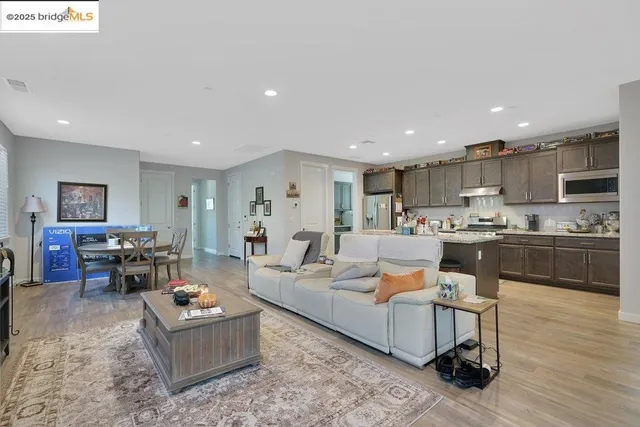 a kitchen with stainless steel appliances granite countertop a sink a stove a microwave a refrigerator and cabinets