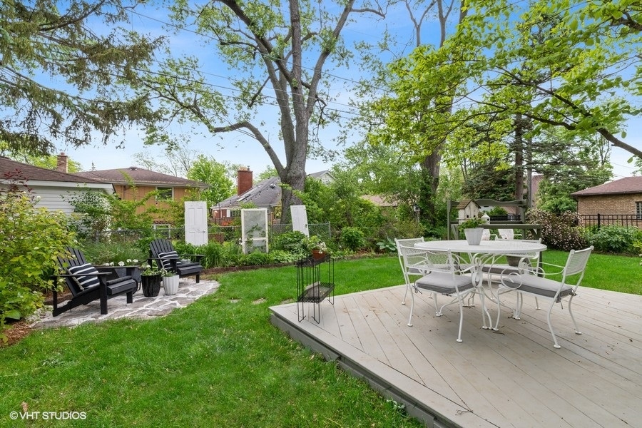 321 Stratford Road Des Plaines, IL 60016 - Photo 10 of 10 a white bench sitting in a yard with plants and large trees