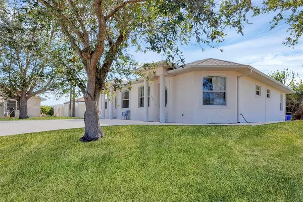a front view of house with yard and trees around