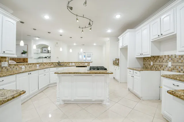 a large white kitchen with cabinets