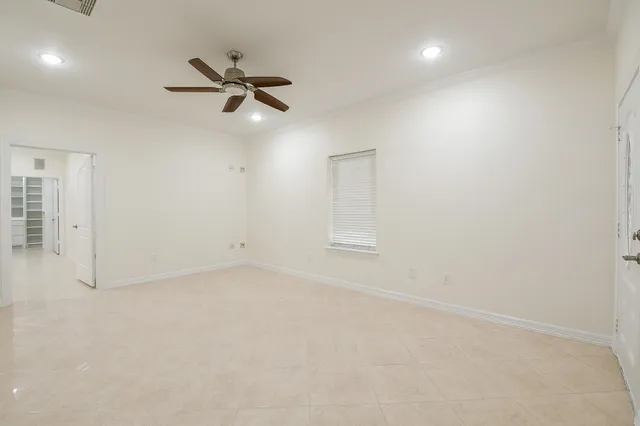 an empty room with a window and a ceiling fan