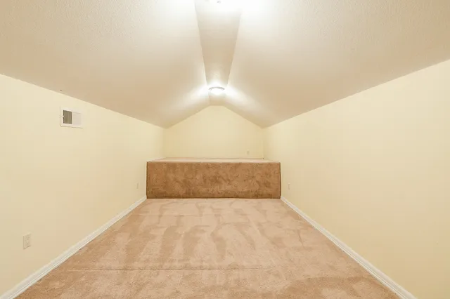 an empty room with chandelier fan and windows