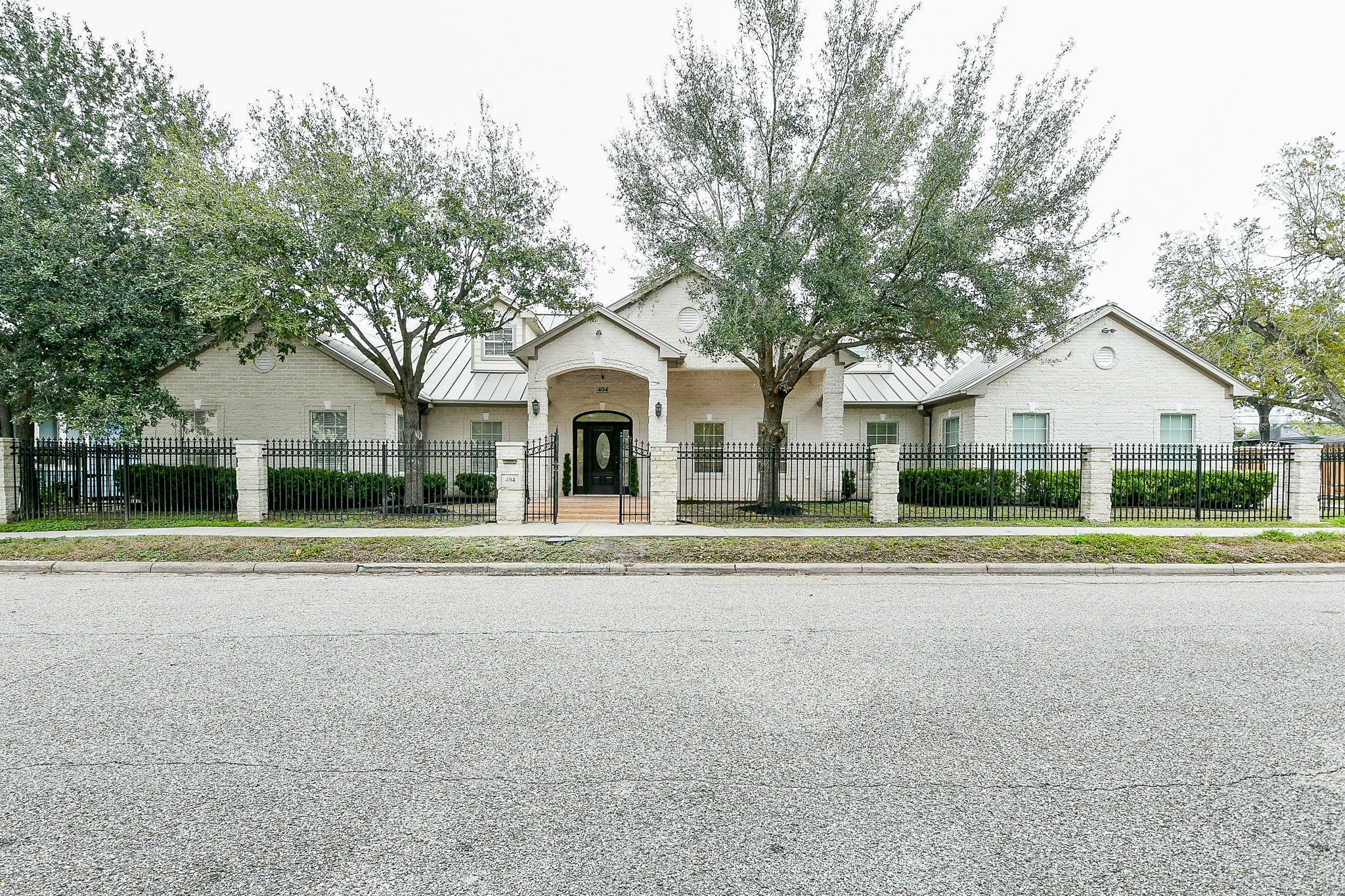 404 Moss Street Houston, TX 77009 - Photo 4 of 40 a view of a white house with a yard and large trees