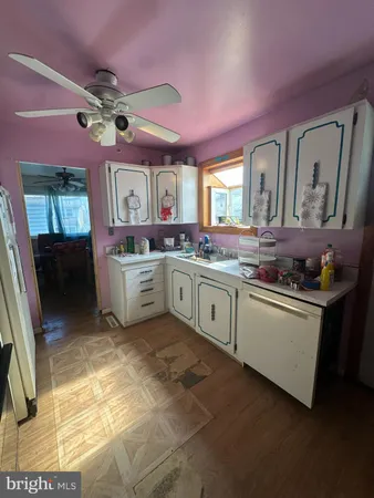 a kitchen with stainless steel appliances granite countertop a sink cabinets and wooden floor