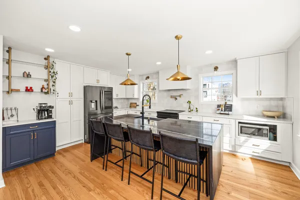 a kitchen with stainless steel appliances a dining table chairs stove and refrigerator
