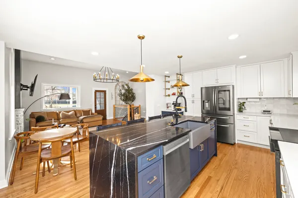 a kitchen with stainless steel appliances granite countertop a sink a stove and a refrigerator