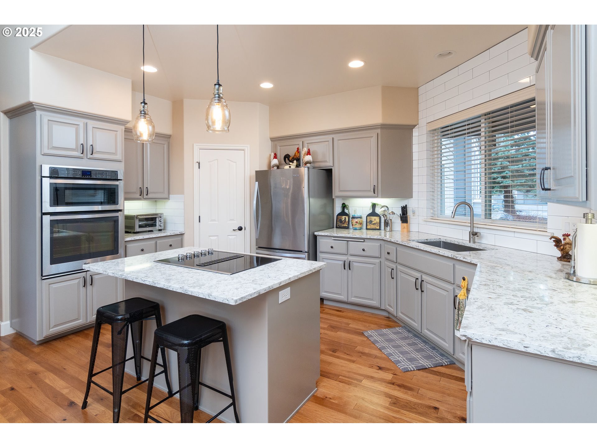 8830 Merlin Drive Redmond, OR 97756 - Photo 10 of 32 a kitchen with stainless steel appliances kitchen island granite countertop a sink refrigerator and cabinets