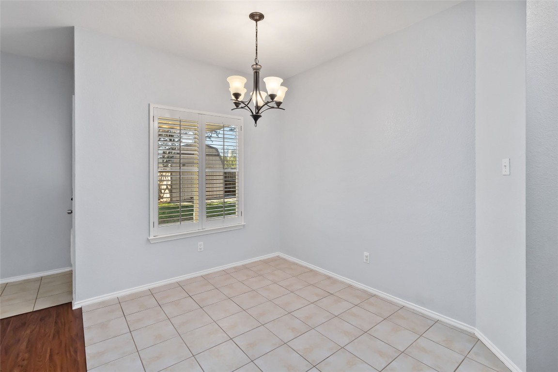 1320 Lochaline Loop Pflugerville, TX 78660 - Photo 20 of 35 Unfurnished room with a chandelier and light tile patterned floors