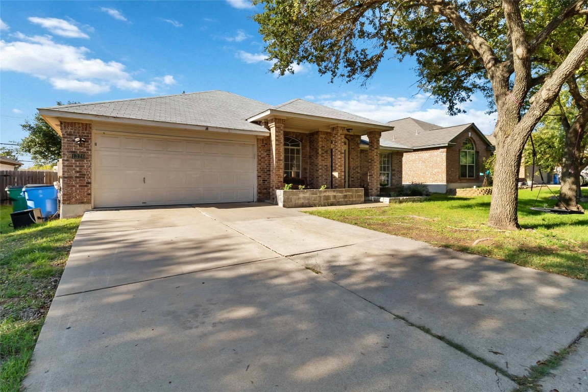 1320 Lochaline Loop Pflugerville, TX 78660 - Photo 2 of 35 Ranch-style house featuring brick siding, a front yard, concrete driveway, and a garage