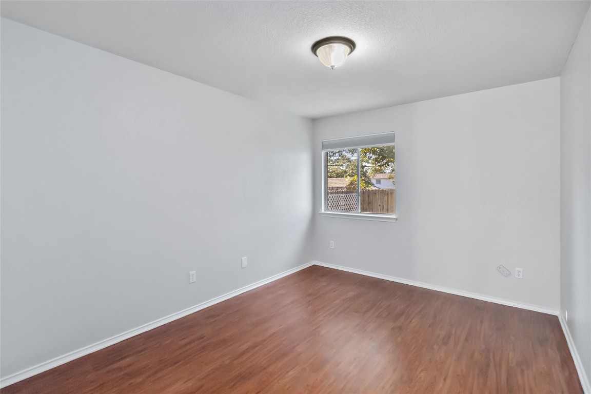 1320 Lochaline Loop Pflugerville, TX 78660 - Photo 24 of 35 Empty room featuring dark wood-type flooring and baseboards
