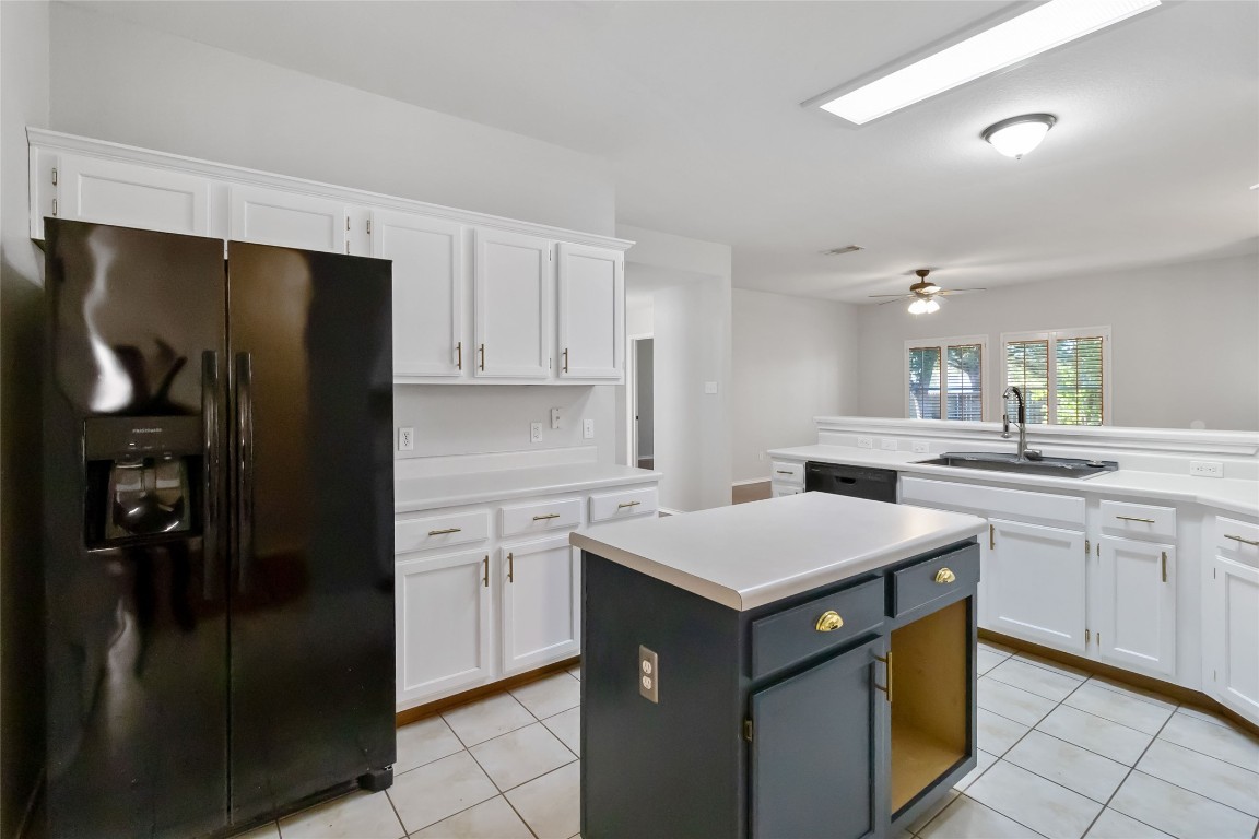 1320 Lochaline Loop Pflugerville, TX 78660 - Photo 9 of 35 Kitchen featuring black appliances, white cabinetry, a kitchen island, light countertops, and light tile patterned floors