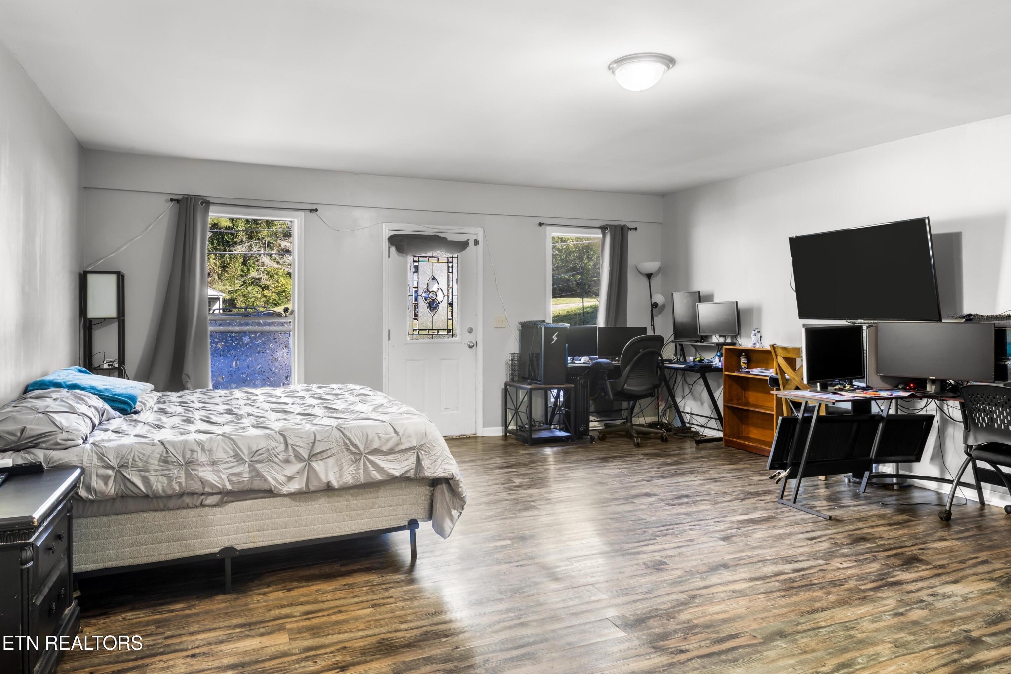657 Robertsville Road Oak Ridge, TN 37830 - Photo 16 of 28 a bedroom with a bed a couch and a flat screen tv