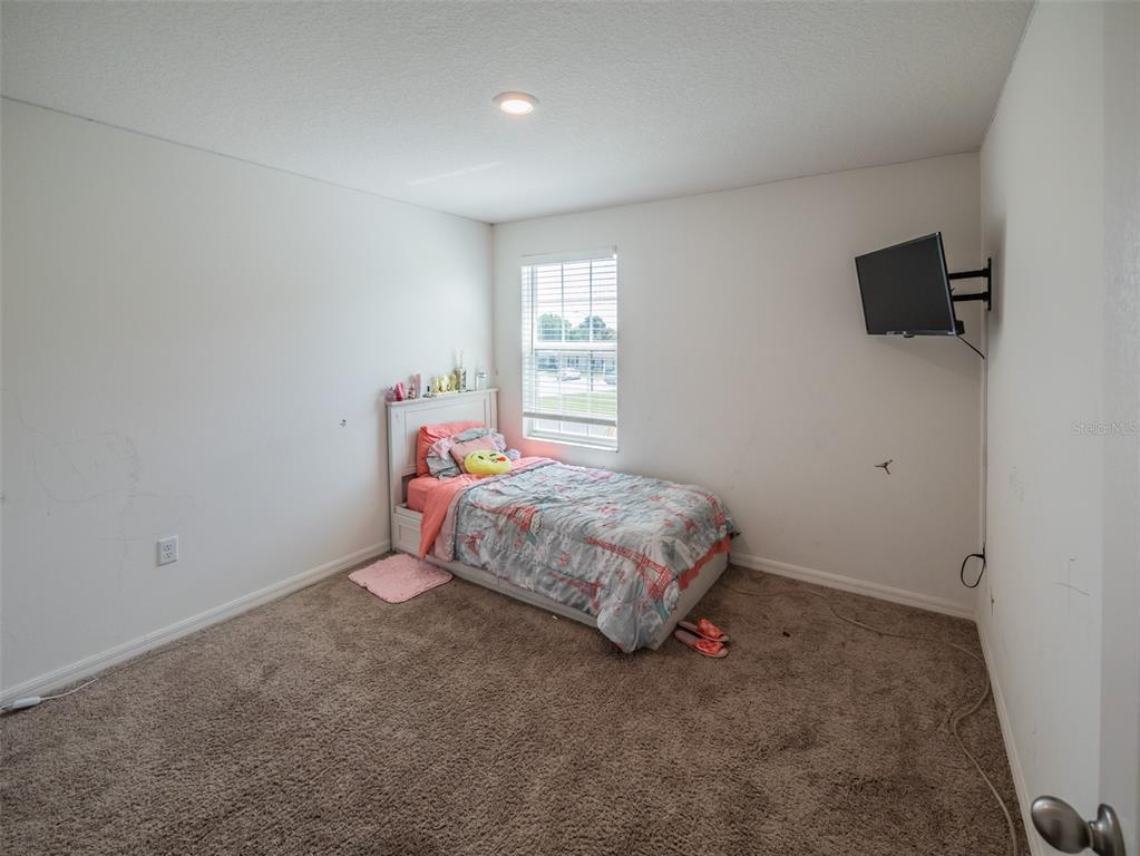 938 Mansfield Road Tavares, FL 32778 - Photo 13 of 25 a bedroom with a bed and a tv