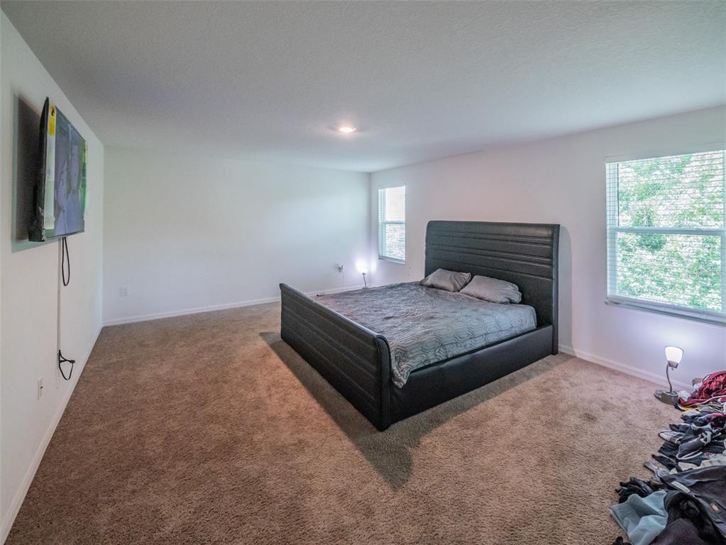 938 Mansfield Road Tavares, FL 32778 - Photo 14 of 25 a bedroom with a bed and flat screen tv