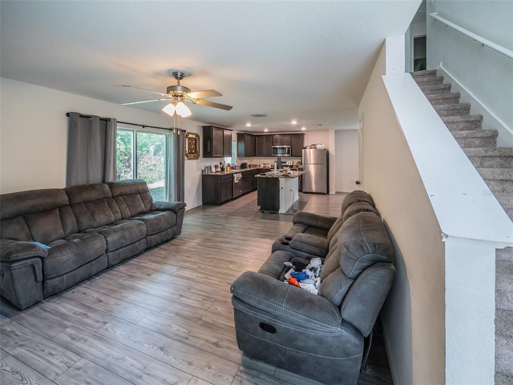 938 Mansfield Road Tavares, FL 32778 - Photo 5 of 25 a living room with furniture ceiling fan and a rug