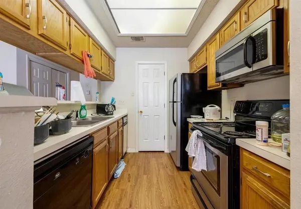 a kitchen with stainless steel appliances a stove a sink and a refrigerator