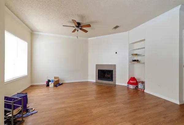 a view of a livingroom with wooden floor and a ceiling fan