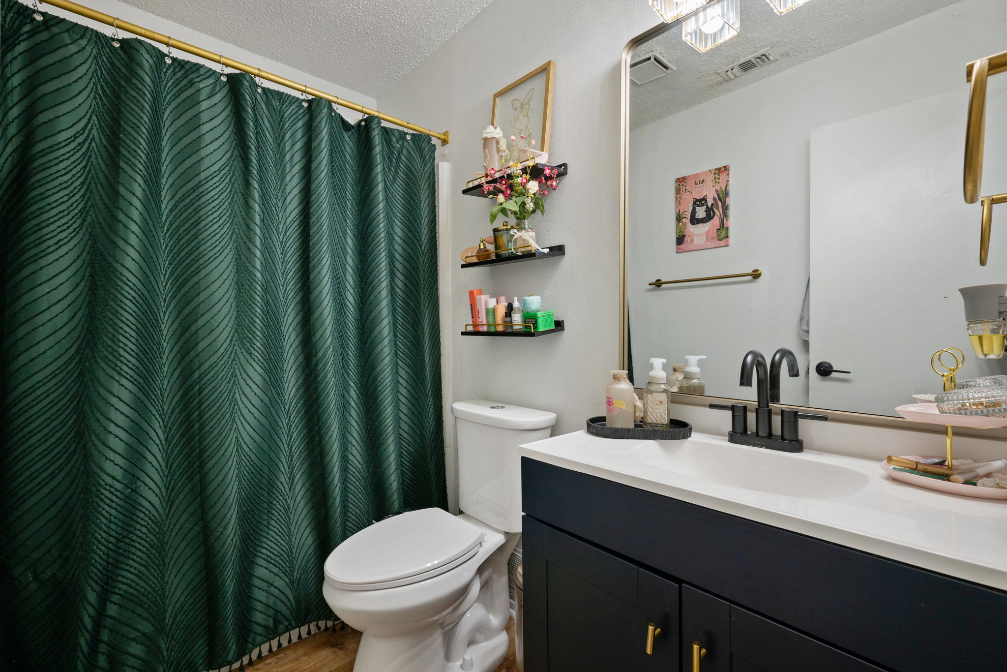 8317 Forest Ridge Drive San Antonio, TX 78239 - Photo 15 of 26 Stylish vanity with a contemporary black faucet complements the deep green shower curtain.