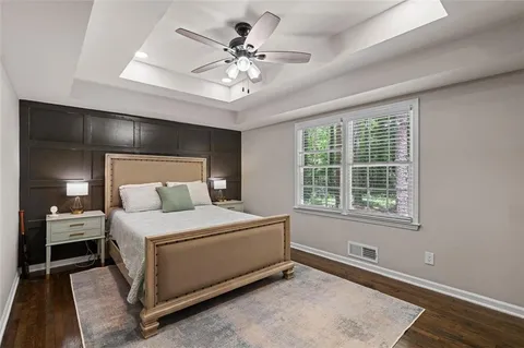 a bedroom with a large bed and a chandelier