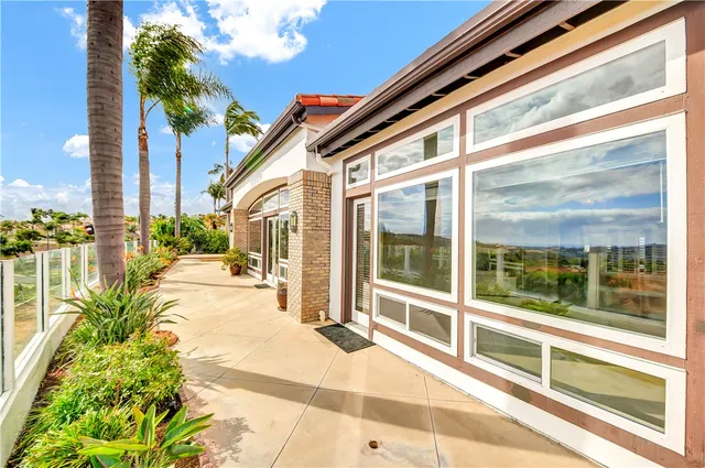 a view of a balcony with a floor to ceiling window and potted plants