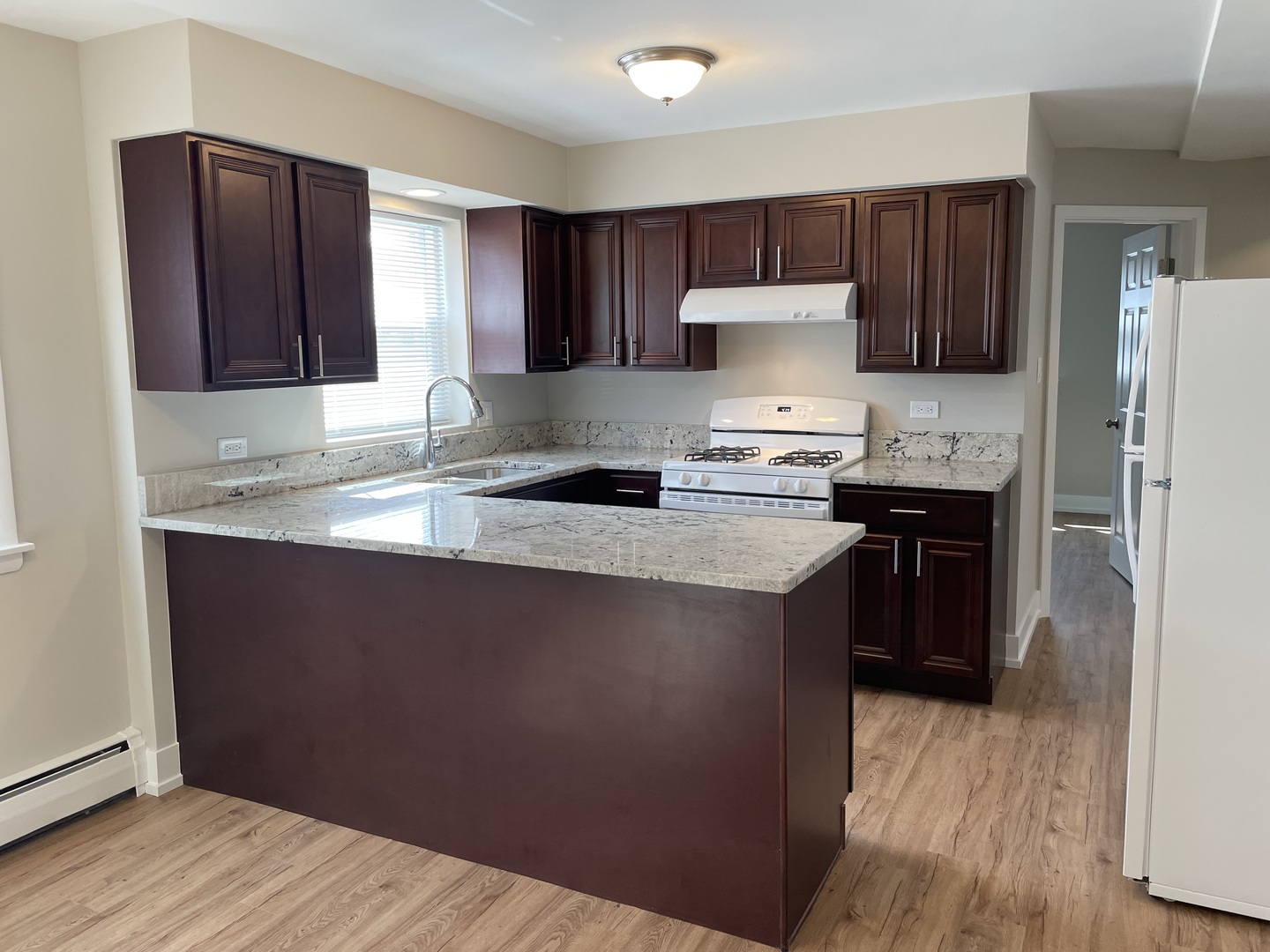 7541 Roberts Road, Unit 1 Bridgeview, IL 60455 - Photo 3 of 10 a kitchen with granite countertop wooden cabinets a refrigerator a sink and dishwasher a stove with wooden floor