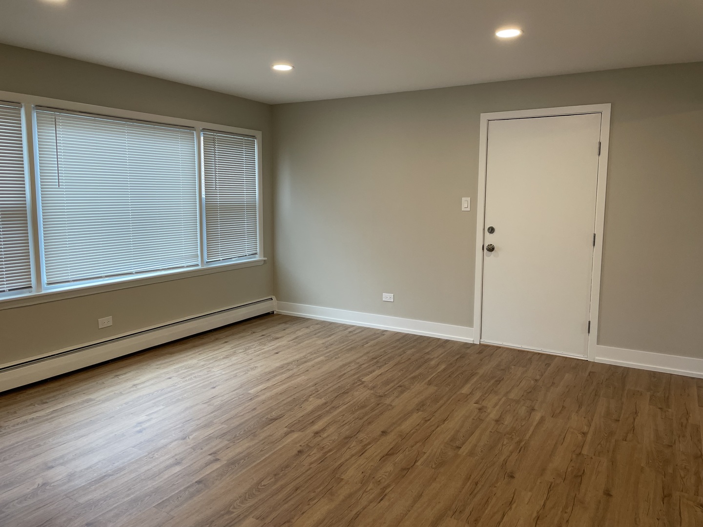 7541 Roberts Road, Unit 1 Bridgeview, IL 60455 - Photo 7 of 10 an empty room with wooden floor and windows