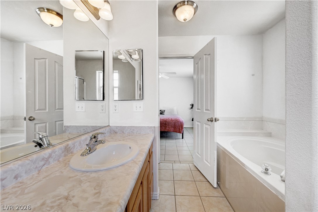 1272 Liston Avenue Logandale, NV 89021 - Photo 41 of 61 A bright bathroom with a spacious bathtub and a wide vanity leads directly into a private bedroom.