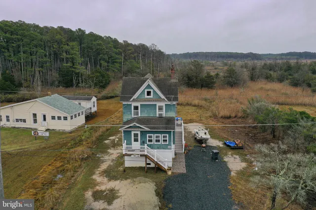 a view of a house with a small yard and wooden fence