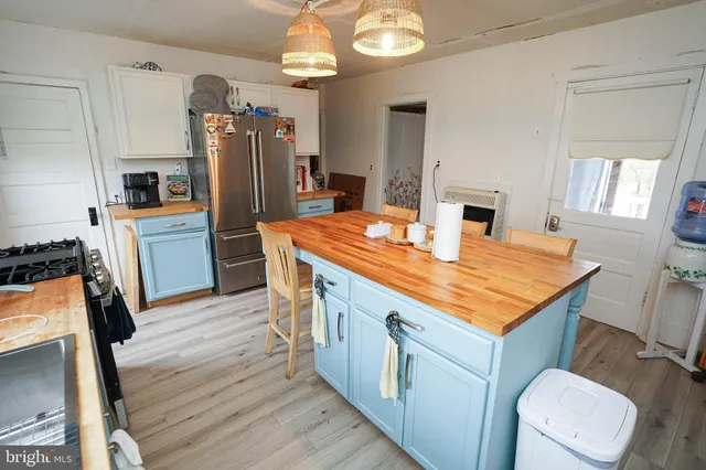 a view of a kitchen with fridge and workspace