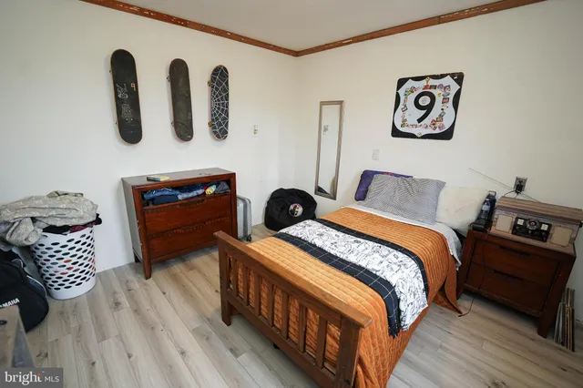 a bedroom with a bed and a flat tv screen on the dresser