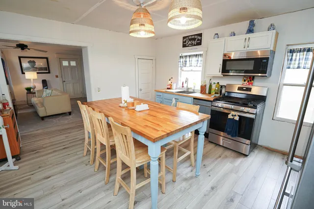 a kitchen that has a table chairs in it and wooden floor