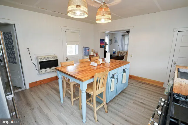 a kitchen that has a kitchen island wooden floor and stainless steel appliances