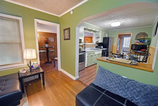 a kitchen with a table chairs wooden floors and stainless steel appliances