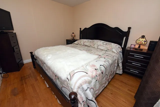 a bedroom with a bed and a lamp on the dresser