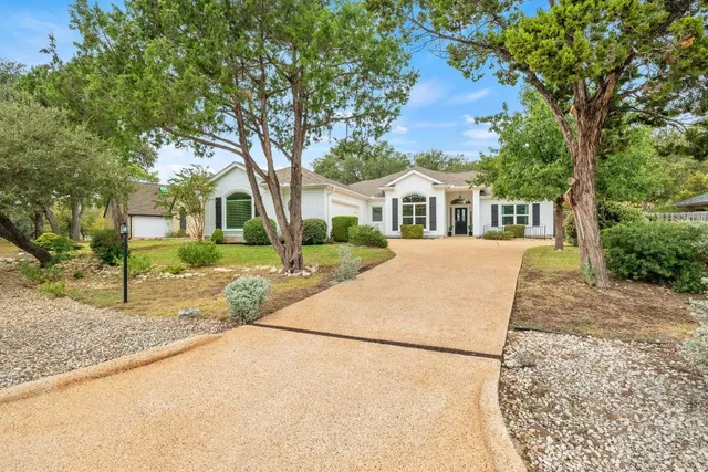 a front view of a house with a yard and trees
