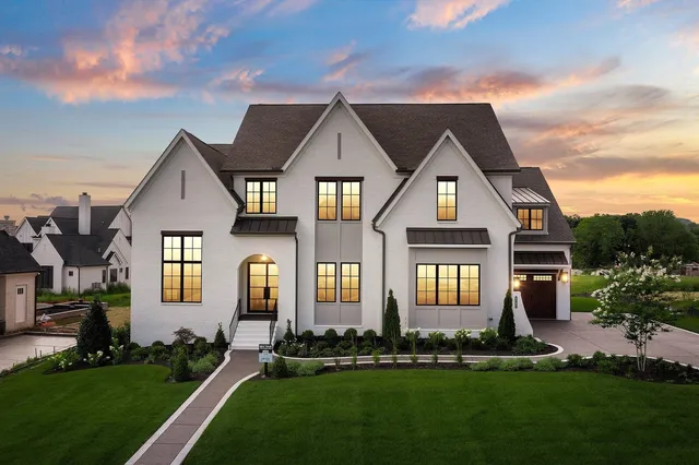 front view of a house with a yard and an trees
