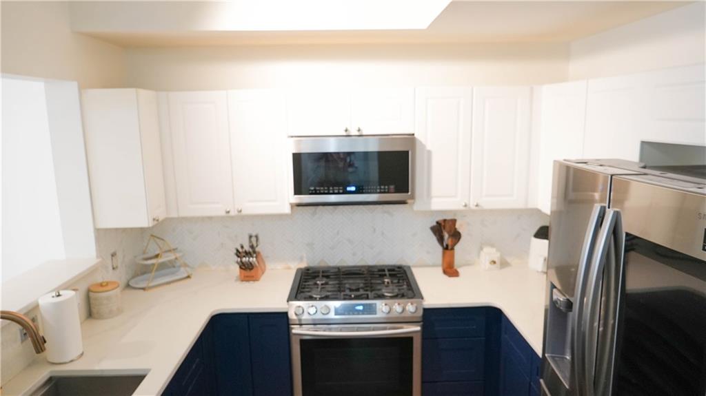 3275 Lenox Road Northeast, Unit 107 Atlanta, GA 30324 - Photo 11 of 18 a kitchen with a stove and a microwave