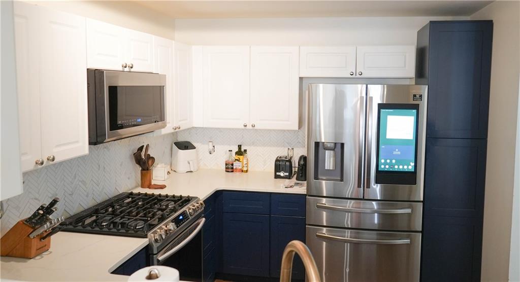 3275 Lenox Road Northeast, Unit 107 Atlanta, GA 30324 - Photo 4 of 18 a kitchen with stainless steel appliances granite countertop a refrigerator and a stove top oven