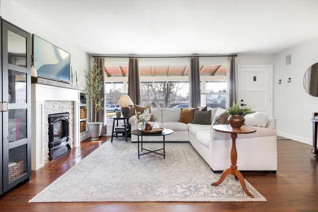 a living room with furniture a large window and a fireplace