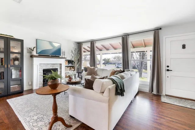 a living room with furniture a fireplace and a floor to ceiling window