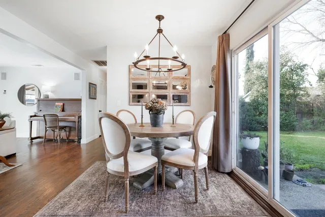 a dining room with furniture a chandelier and wooden floor