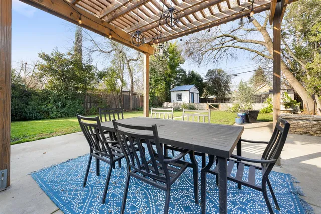 a view of an outdoor dining space with furniture and garden
