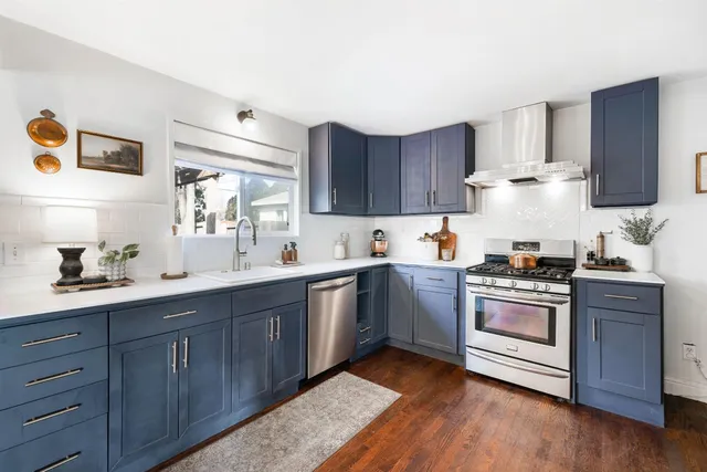 a kitchen with granite countertop wooden cabinets and white stainless steel appliances
