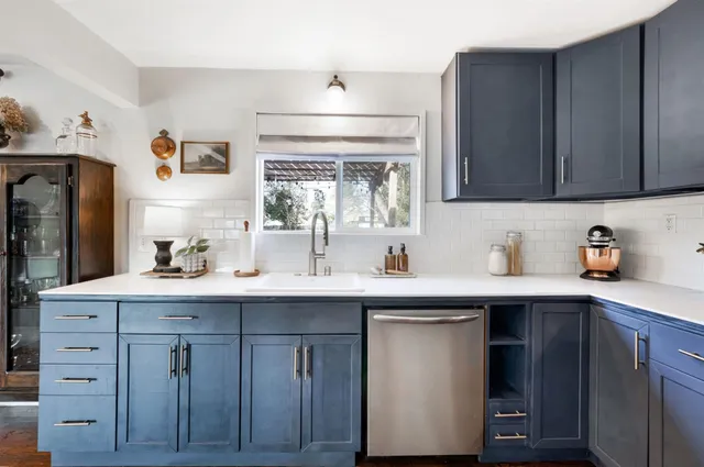 a kitchen with cabinets wooden floor and stainless steel appliances