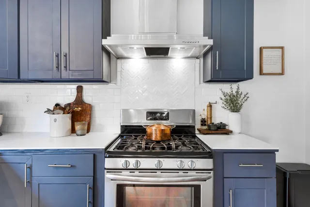 a stove top oven sitting inside of a kitchen and granite counter tops