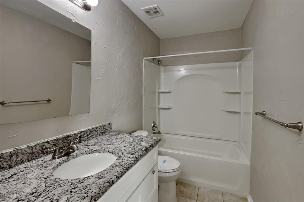 7709 Harbor Drive Rowlett, TX 75088 - Photo 14 of 19 a bathroom with a granite countertop sink toilet and shower