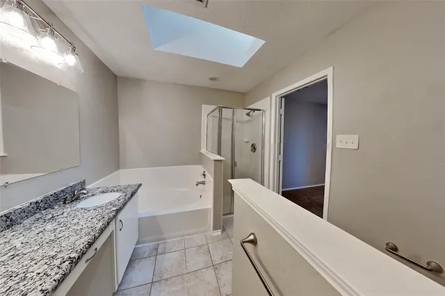 a bathroom with a granite countertop sink a bathtub and shower