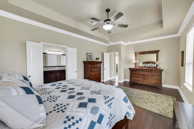 a bedroom with a large bed and a chandelier