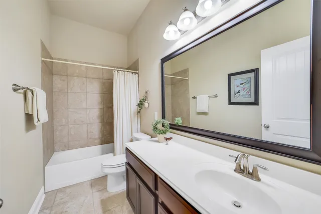 a bathroom with a sink a toilet a mirror a bathtub and shower