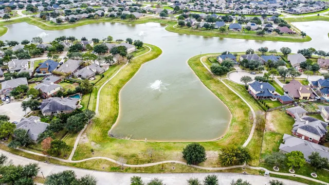 an aerial view of a swimming pool with outdoor seating and yard